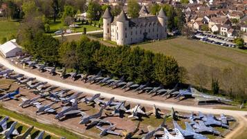 Vista aérea de um castelo cercado por uma extensa coleção de aeronaves militares.