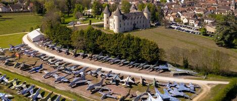 An aerial view of a castle surrounded by a large collection of military aircraft.