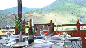 A table set for dining with a bottle of Moët & Chandon champagne, glasses of wine, and a vase with flowers. - Paro Grand Resort (Paro)