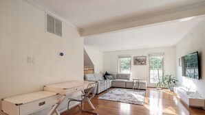 Een moderne woonkamer met een bank, een bureau en een televisie.