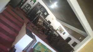 Una escalera conduce a una zona de descanso con un sofá y un papel tapiz estampado.