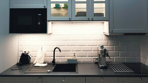 A modern kitchen with a built-in microwave, a coffee machine, and a sink. - Vintage Charm in Old Town Krakow -8 min walk to Krakow’s Main Square! Sleeps 6 (Kraków)