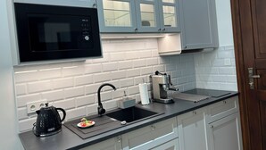 A modern kitchen with a black microwave, a coffee machine, and a kettle on the counter. - Vintage Charm in Old Town Krakow -8 min walk to Krakow’s Main Square! Sleeps 6 (Kraków)