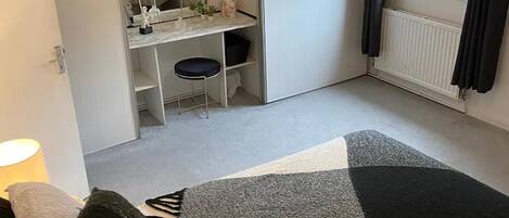 Une chambre à coucher avec un lit, un bureau et une fenêtre.
