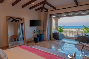 A spacious bedroom with a large bed, a TV, and a balcony with a view of the sea. - Stunning Ocean Views, Private Pool, & Seaside Golf (Cabo San Lucas)