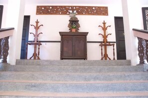 A staircase with a wooden cabinet and a decorative panel above. - Sea Wind Resort (Boracay Island)