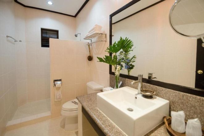 A modern bathroom with a large sink, toilet, and shower area.