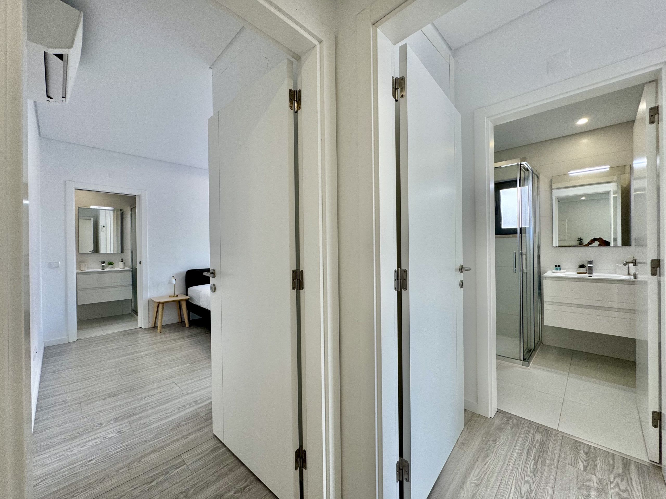 A hotel room with a bathroom, a bed, and a small table.
