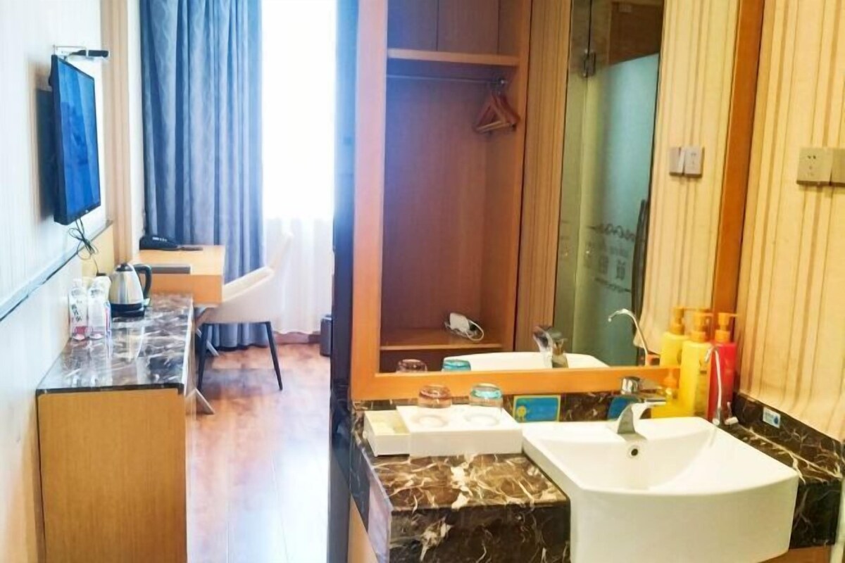 A modern bathroom with a large mirror, a sink, and a shower area.