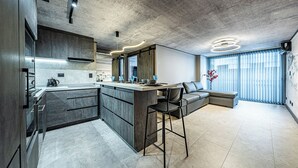 A modern kitchen with a central island, bar stools, and a built-in oven. - Design Tech Comfort & Location. Everything you are looking for in the best place (Santiago)
