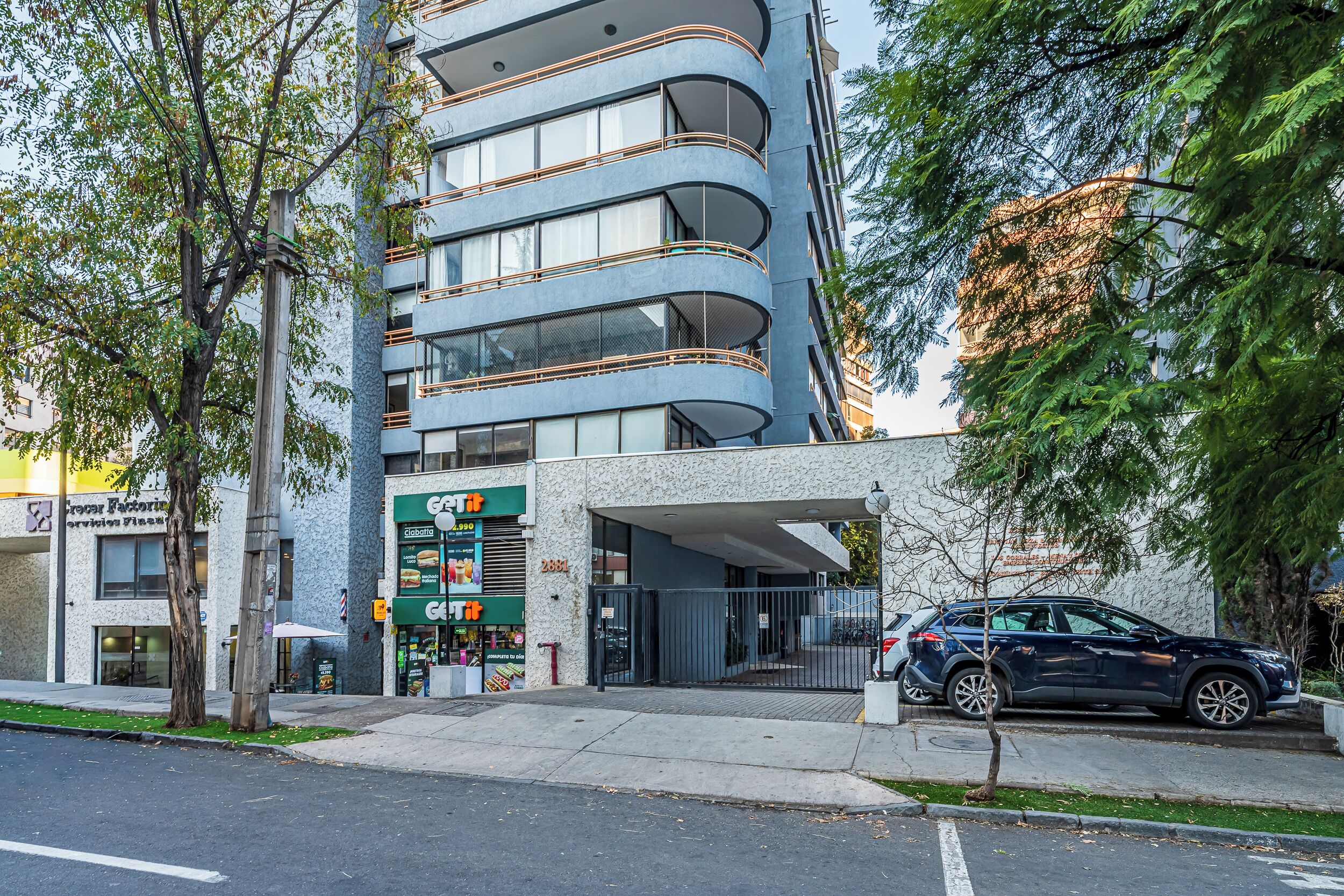 A multi-story building with a modern design, featuring balconies and large windows.