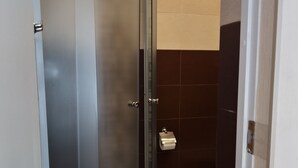 Ein Badezimmer mit Duschkabine, Toilette und Handtuchhalter.