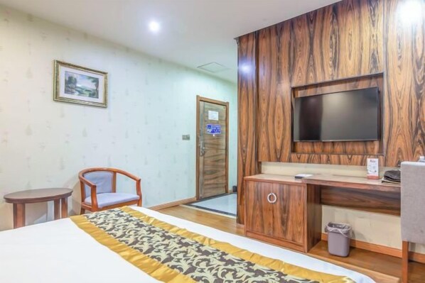 A hotel room with a bed, a wooden cabinet, a television, and a small table. - Luoyang Hotel (Wanda Plaza Guangzhou Market Branch) (Luoyang)