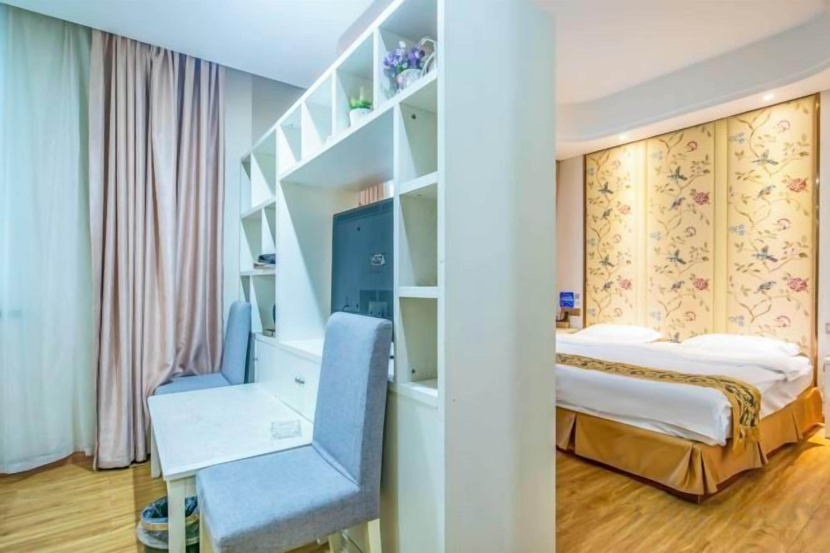 Una habitación de hotel con una cama, un escritorio y una silla.