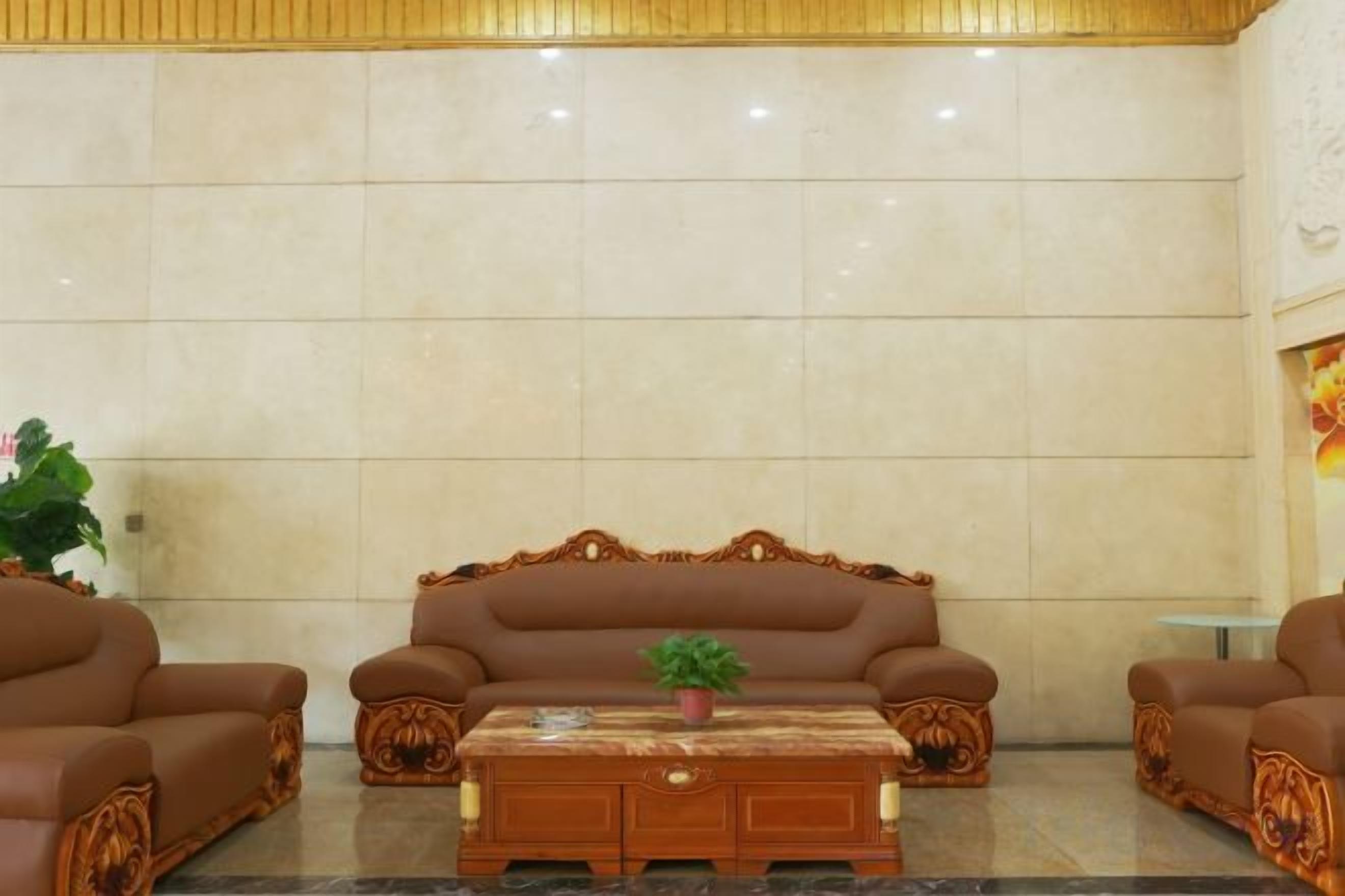 A lobby with a large sofa, a coffee table, and a small table with a plant.