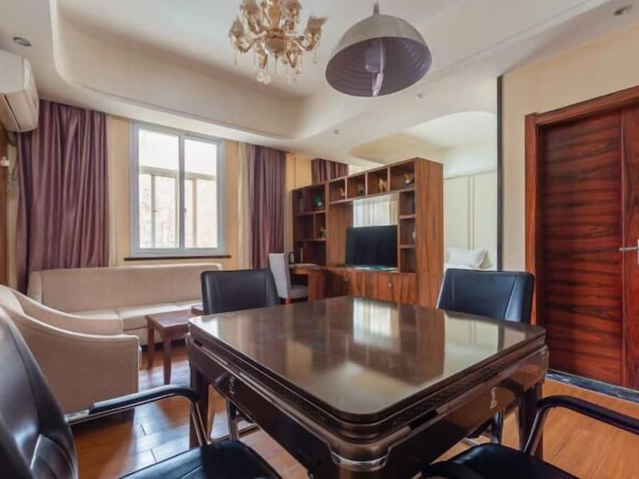 Un salón de conferencias con una gran mesa, sillas, un sofá y una televisión.