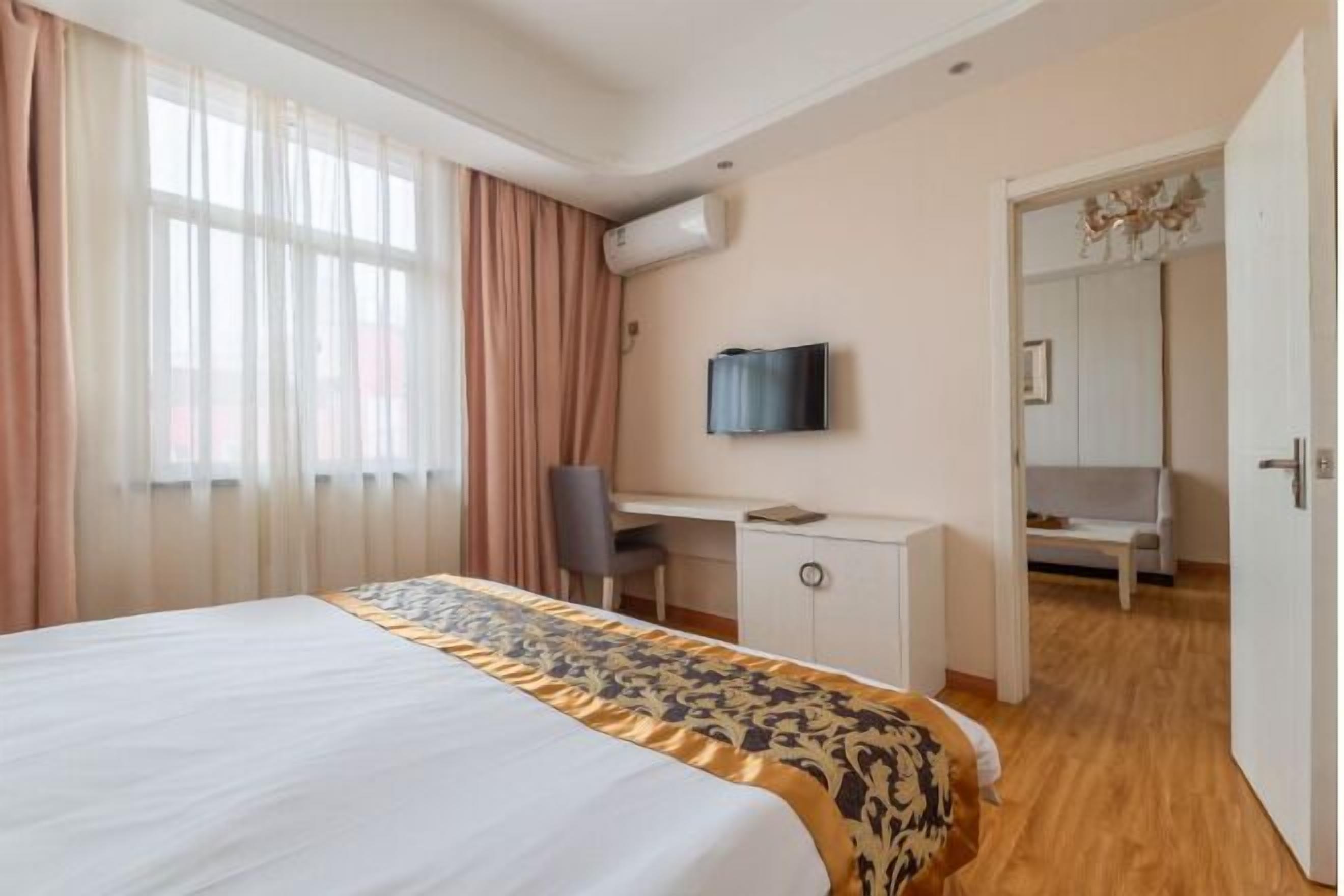 Une chambre d’hôtel équipée d’un lit, d’un bureau, d’une chaise, d’une télévision et d’un appareil de climatisation.