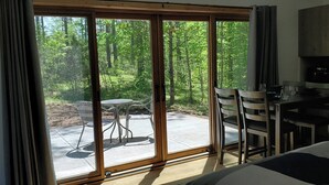 A room with a sliding glass door leading to an outdoor patio with a table and chairs. - Expedition Inn (Calumet)