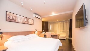 A hotel room with a large bed, a desk, a chair, a TV, and a window with curtains. - Jinjiang Inn Select (Foshan Guicheng Metro Station) (Foshan)