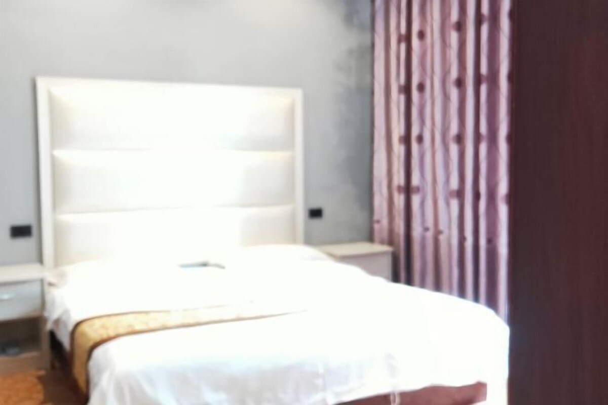Ein Hotelzimmer mit einem großen Bett, einem Nachttisch und einem Holzkopfstück.