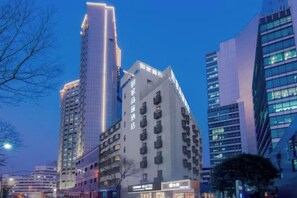 A high-rise building with multiple floors, large windows, and a modern architectural design. - Homeinn Selected Hotel (Shanghai Train Station South Square) (Shanghai)