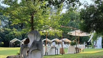 A campsite with tents, a swing set, and a large sculpture.