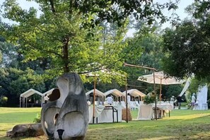 Un camping con tiendas de campaña, un columpio y una escultura grande.