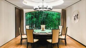 Un espace repas comprenant une table ronde, des chaises et un lustre.
