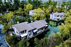 Una casa con un muelle, rodeada de agua y árboles.