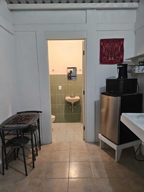 A compact kitchen with a dining area, a sink, and a microwave. - Studio cottage ideally located in Oaxaca's Historical District (Oaxaca de Juárez)