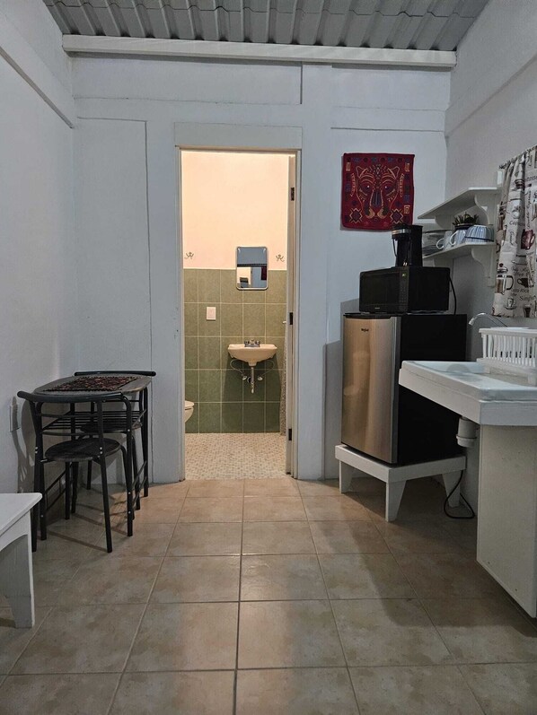A compact kitchen with a dining area, a sink, and a microwave. - Studio cottage ideally located in Oaxaca's Historical District (Oaxaca de Juárez)