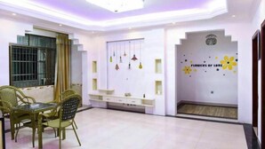 A modern living room with a dining area, a built-in TV, and decorative wall art. - Hongya Hansongyuan Inn (Hongya)