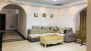 A modern living room with a sofa, a coffee table, and a chair. There are three framed pictures on the wall. - Hongya Hansongyuan Inn (Hongya)