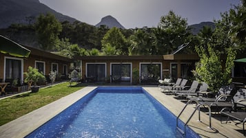 Relax by the pool surrounded by lush greenery and breathtaking mountain views.