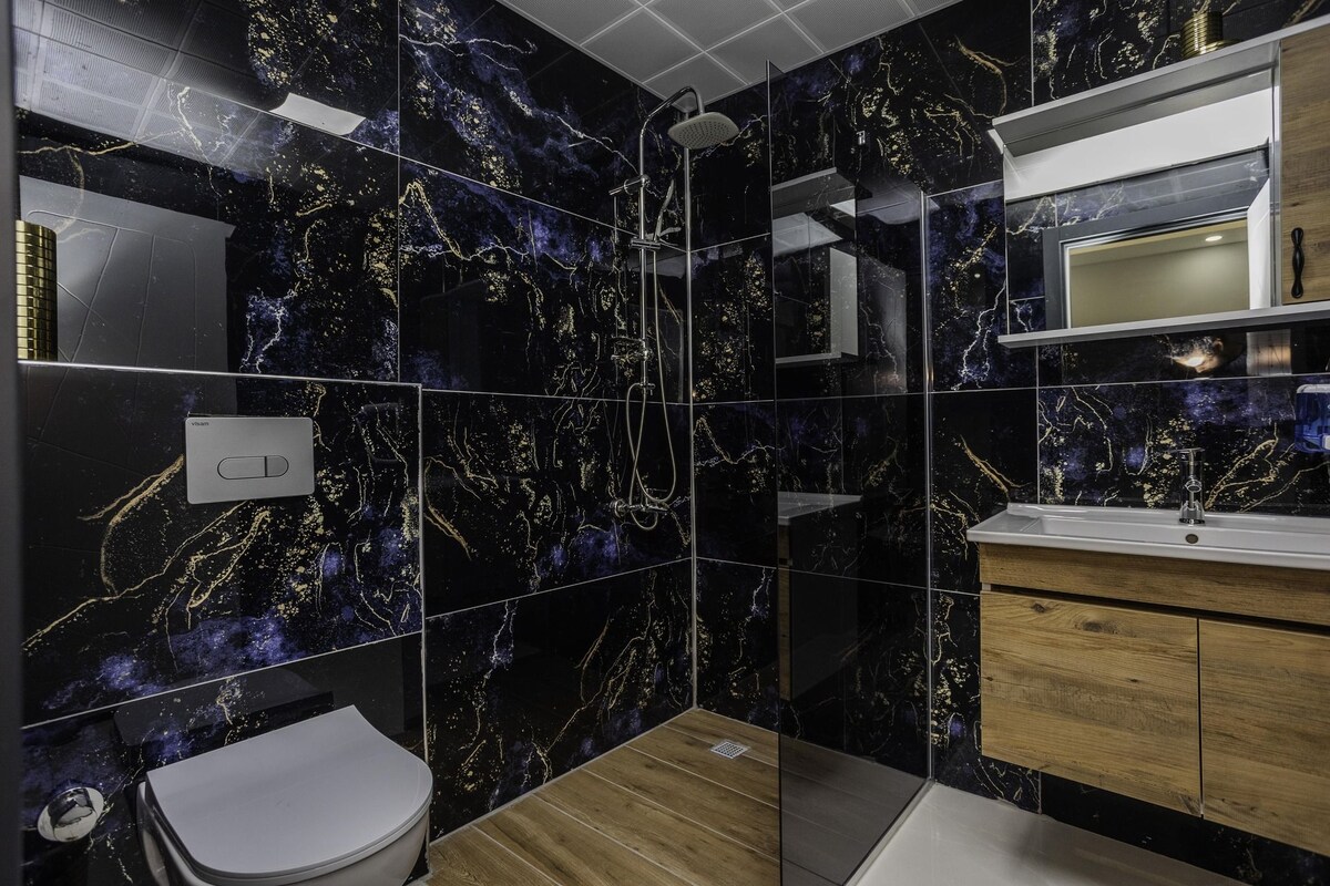 Et moderne badeværelse med brusebad, toilet og vask.