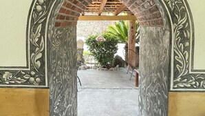 An ornate archway leading to a courtyard with a sign reading "CASA AKBAL Noche Azul". - Casa Akbal (Malinalco)