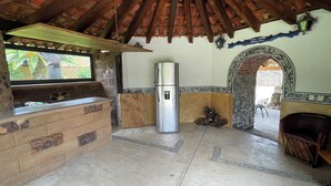 A kitchen with a refrigerator, a window, and a decorative archway. - Casa Akbal (Malinalco)