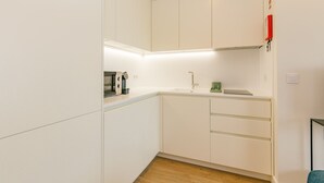 A modern kitchen with white cabinets, a countertop, and a built-in oven.