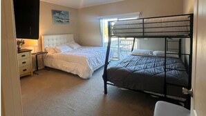 Une chambre avec deux lits, un bureau et une armoire.