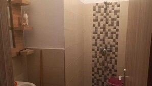 A small bathroom with a shower, a sink, and a toilet. - Marrakech Oasis Retreat - 4 Bed Apartment (Marrakech)