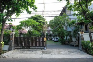 A gated residential area with a paved driveway leading to a house.