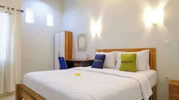 A hotel room with a bed, a desk, and a chair.
