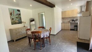 A dining area with a table and chairs, a wooden cabinet, and a painting on the wall.
