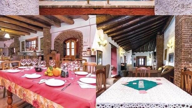 A pool area with a stone wall and a dining room with a red tablecloth. - Casa Rural con Encanto Coronel Cordoba Andalusia (Fuente Obejuna)