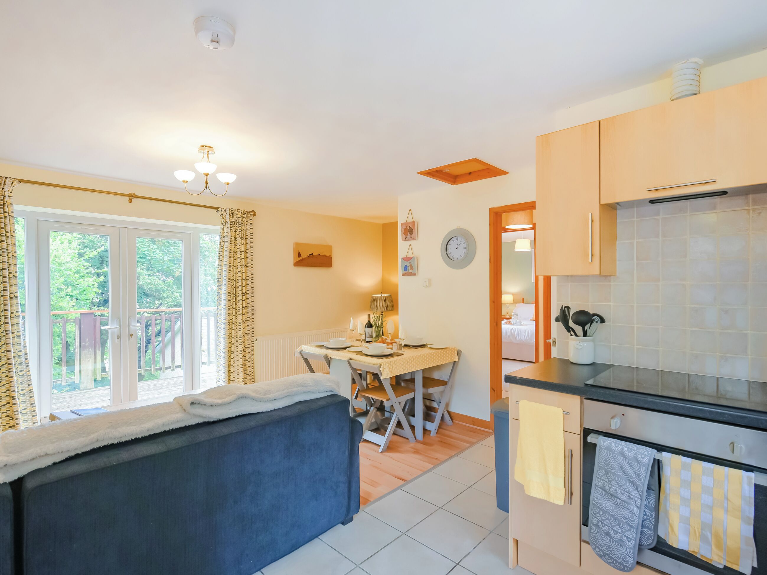 Una cocina compacta con comedor, un sofá y vistas al exterior.