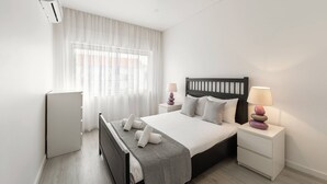 A modern bedroom with a bed, bedside tables, and a window with sheer curtains. - Nazaré Horizon - Balcony View (Nazaré)