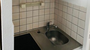 A small kitchen with a sink, a stove, and a cabinet. - Studio Corbier Zodiaque Pool and Ski at the foot of the slopes  (Villarembert)