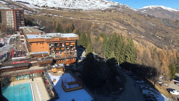 A hotel with a pool, ski resort views, and a mountainous backdrop. - Studio Corbier Zodiaque Pool and Ski at the foot of the slopes  (Villarembert)