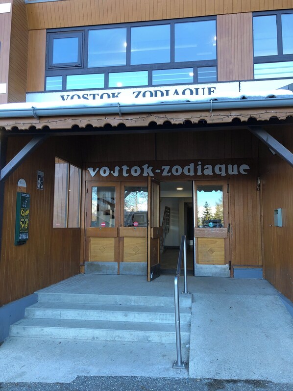 A wooden building with a sign reading "Vostok-Zodiaque" and a staircase leading to the entrance.