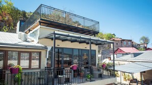 Een modern gebouw met balkon, grote ramen en terras.
